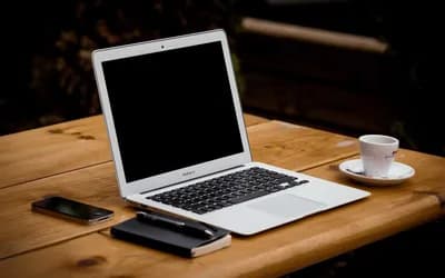 [demo] Laptop on a wooden desk next to a notebook